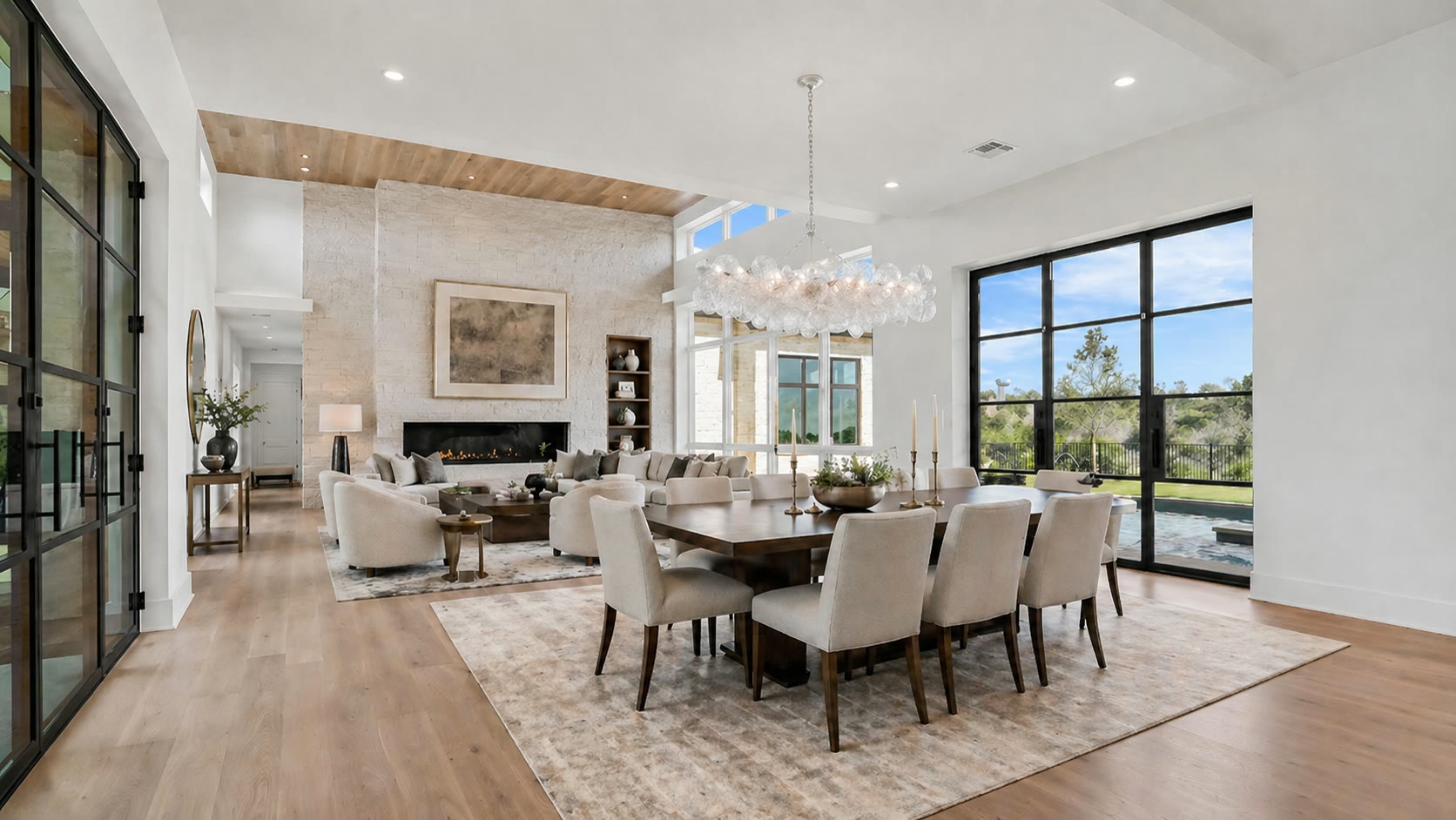 Living and dining rooms with fireplace, steel-framed glass, and pool views at 1043 Overlook Parkway
