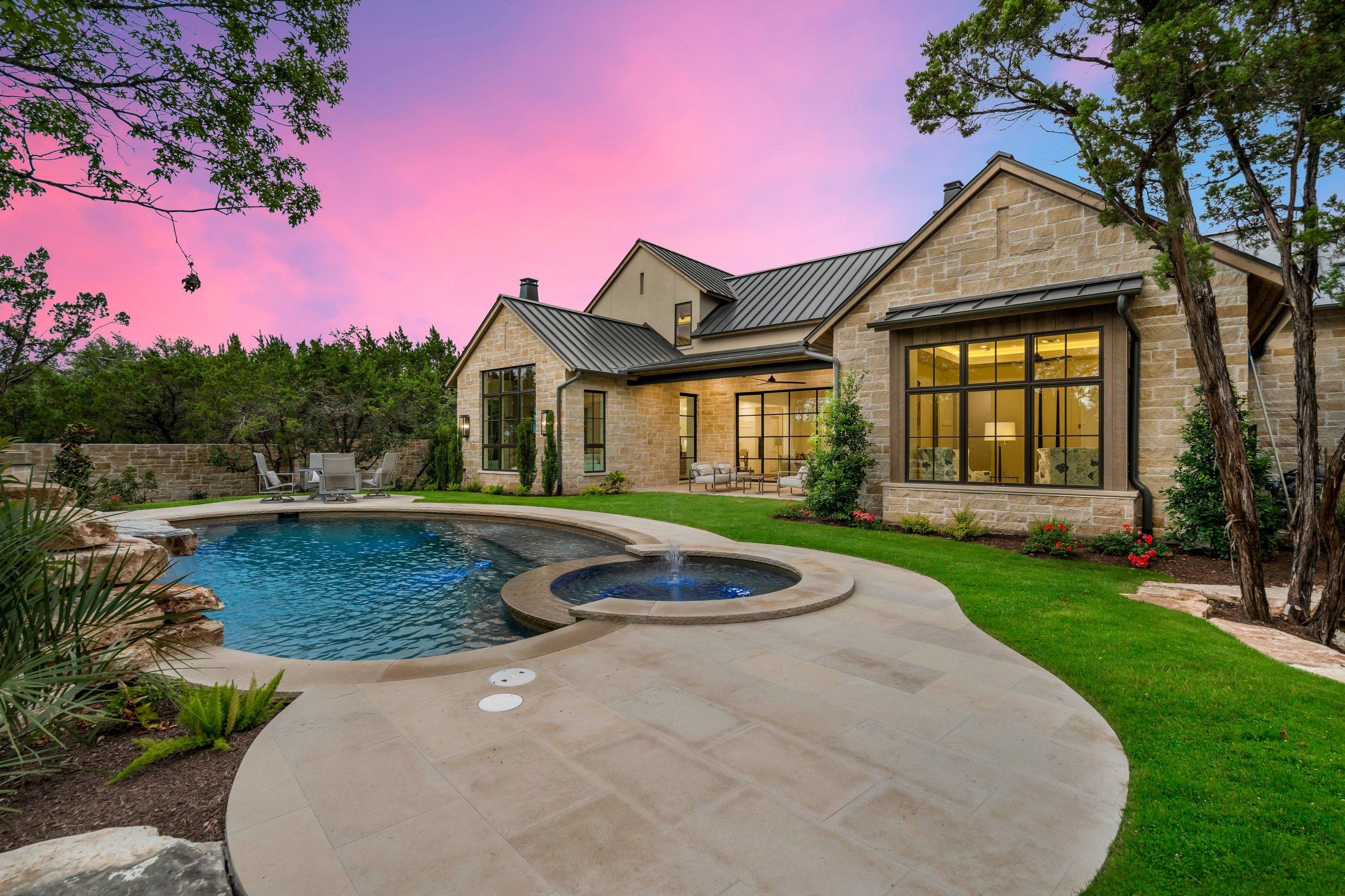 Twilight rear terrace and pool courtyard at 4300 Amarra Drive