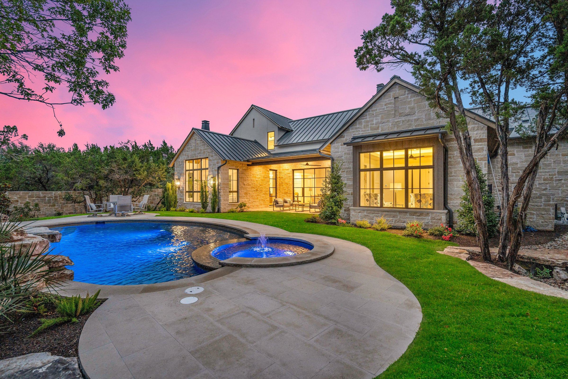 Twilight rear facade, pool, and outdoor living at 4300 Amarra Drive